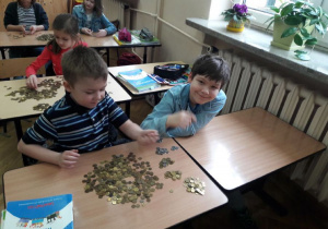 dzieci przeliczają pieniądze zebrane podczas akcji 9